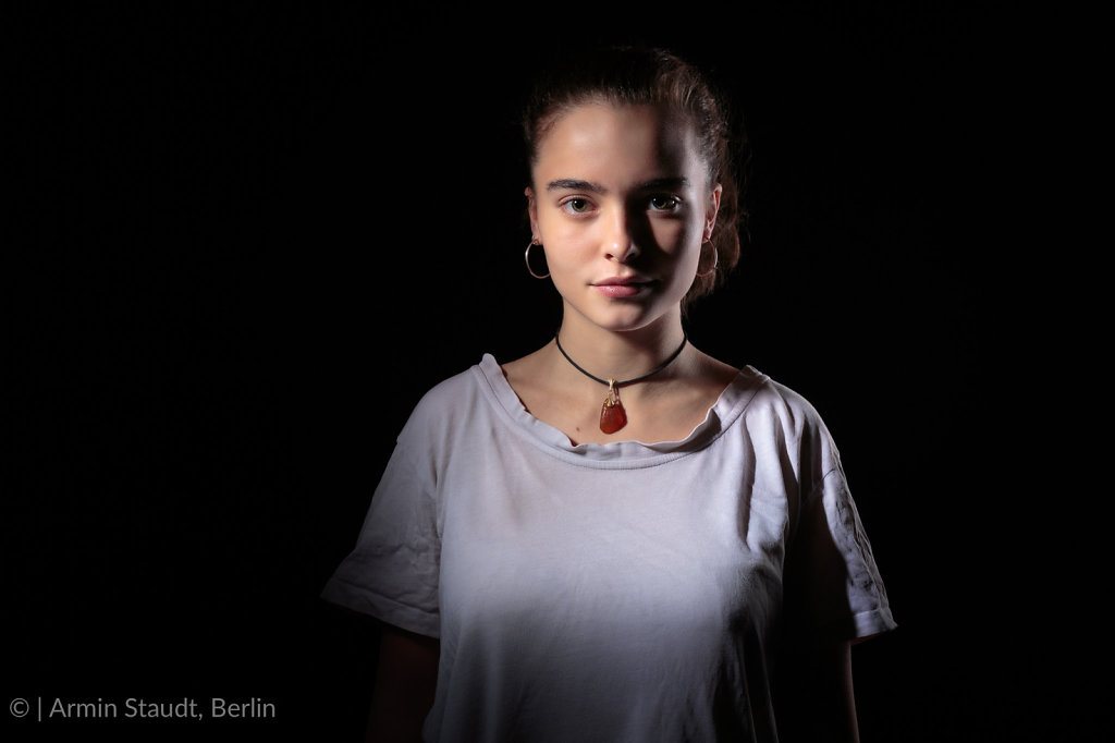 portrait of a beautiful teenage girl with black background