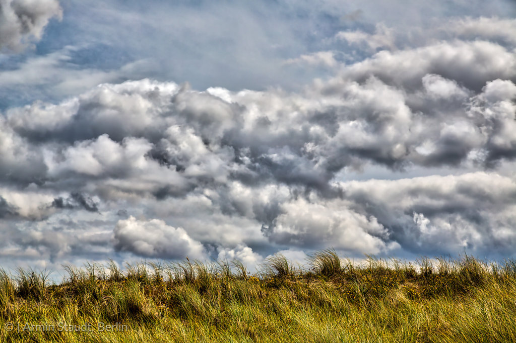 HDR stormy cloudscape and grass dune